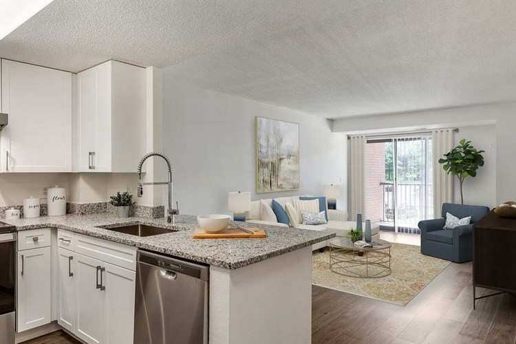 Renovated Package III kitchen and living area with white cabinetry, grey granite countertops, stainless steel appliances, and hard surface plank flooring