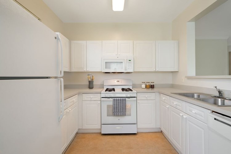 Classic Package I kitchen with white cabinetry, beige laminate countertops, white appliances, and hard surface flooring