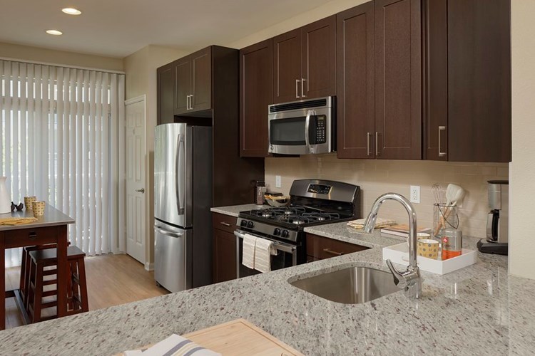 Espresso Finish Package kitchen with granite countertops, stainless steel appliances and hard surface flooring