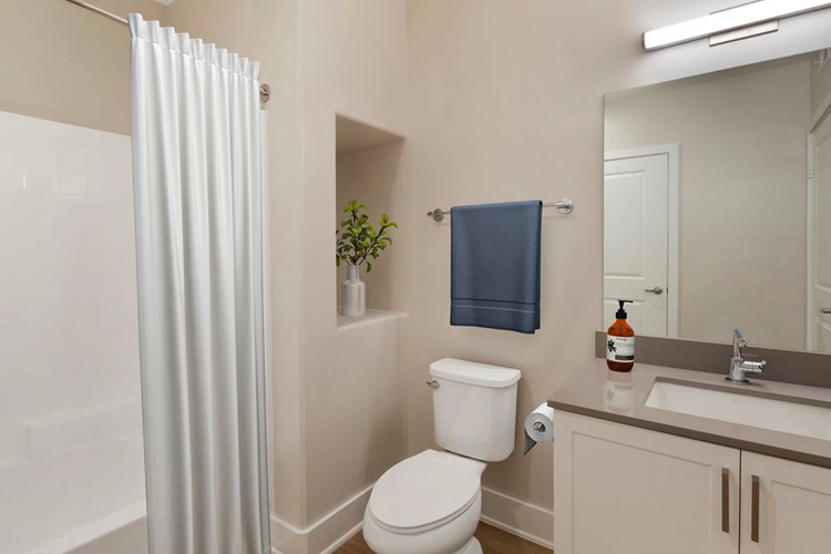 Renovated Package I bath with grey quartz countertops, white cabinetry, and hard surface flooring
