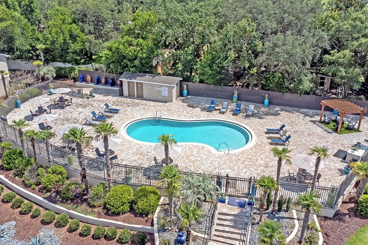 A bird's eye view of our expansive sundeck and resort-style pool surrounded by lush landscaping.