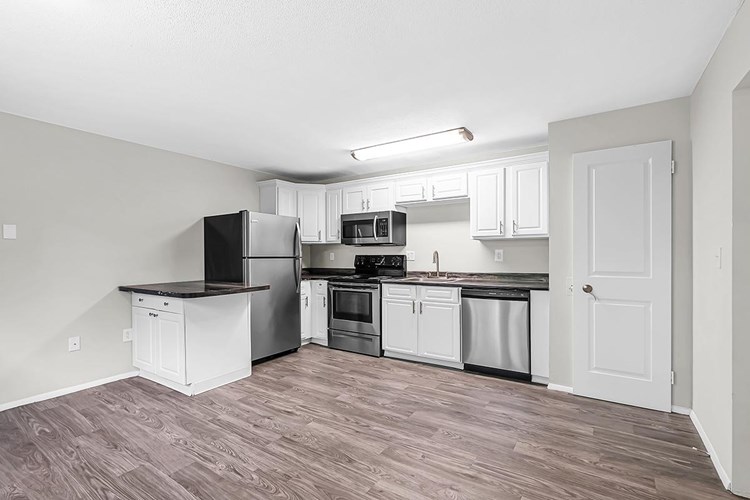 Our 3 bedroom kitchen features wood-style flooring, marble-style countertops, and stainless steel appliances.
