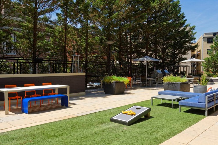 Outdoor chill space with cornhole and lounge seating