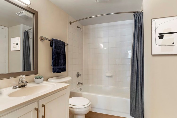Renovated Package I bath with white cabinetry, granite countertops, and hard surface flooring