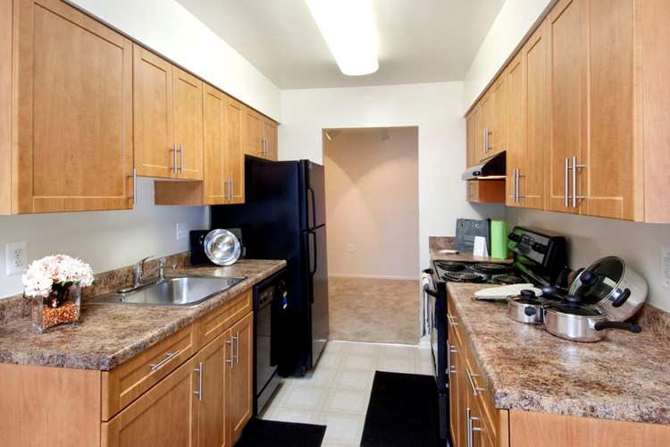 Classic Package kitchen featuring black appliances, oak cabinetry, brown laminate countertops, and tile flooring