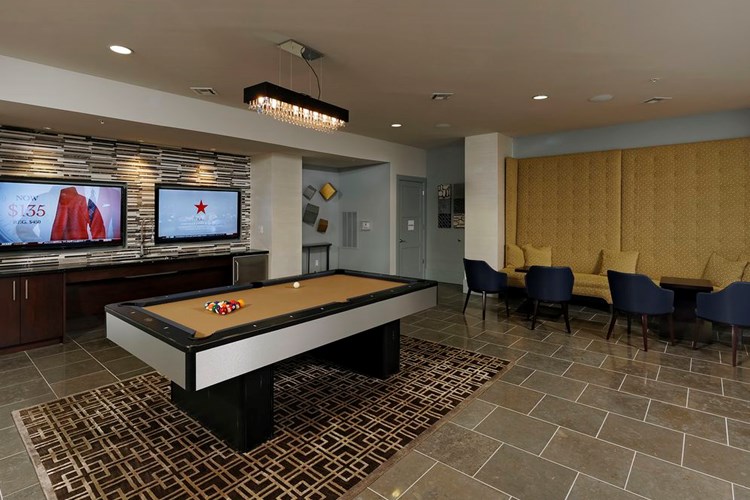 Resident lounge game room with billiards, entertaining kitchen, seating and flat screen televisions