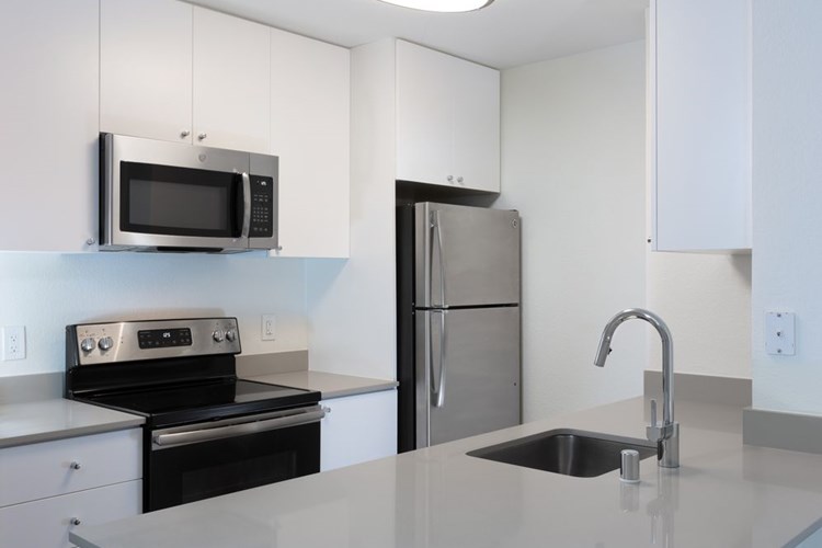 Renovated Package I kitchen with quartz countertops and stainless steel appliances