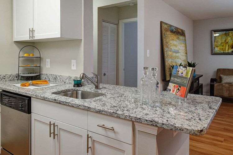 Kitchen has a breakfast bar that opens to the living room available in select homes