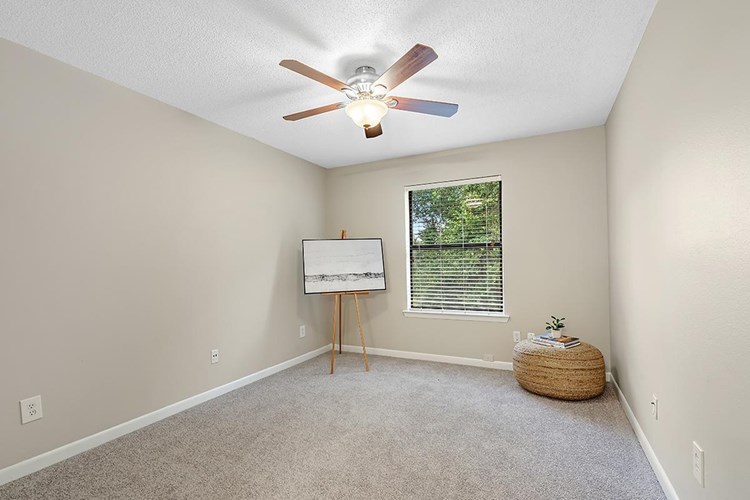 Spacious bedrooms featuring large windows, a multi-speed ceiling fan, and spacious closets.