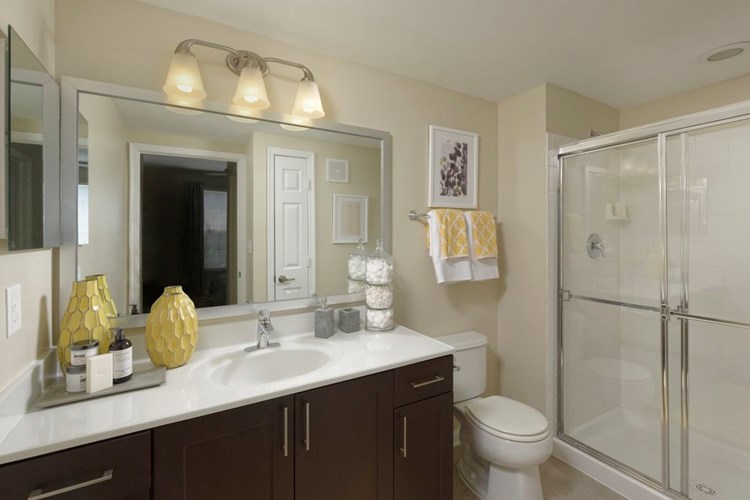Espresso Package Townhome bathroom with espresso cabinetry, quartz countertop and shower with white tile backsplash