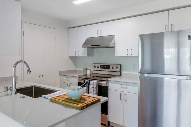 Renovated II kitchen with white cabinetry, grey quartz countertops, stainless steel appliances, and hard surface flooring
