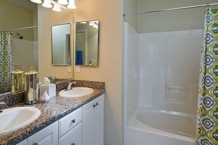 Classic Package I bath with beige speckled granite countertop, white cabinetry, and hard surface flooring