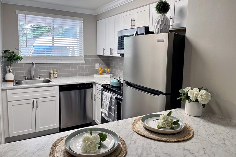 Updated kitchens featuring granite-style countertops, stainless steel appliances, and a backsplash are also available.