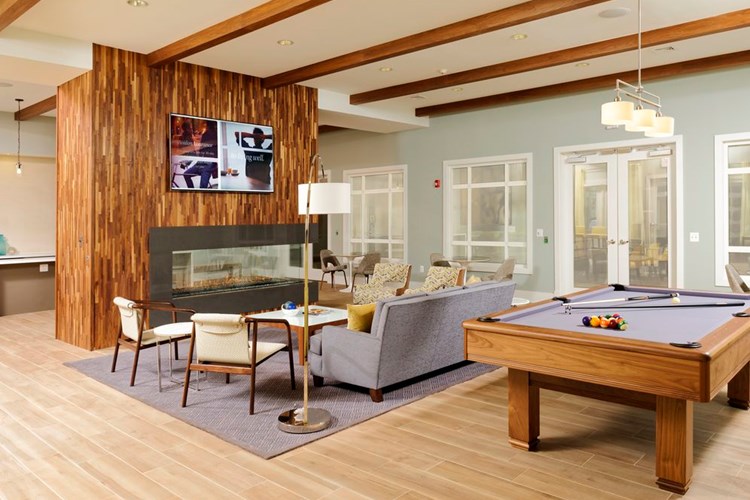 Resident lounge with billiards, flat screen televisions, seating and fireplace