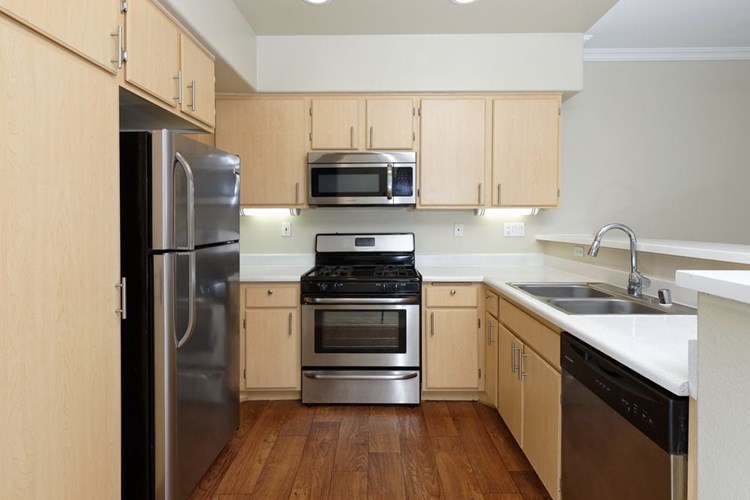 Kitchen with stainless steel appliances, laminate countertops, oak cabinetry, and hard surface flooring