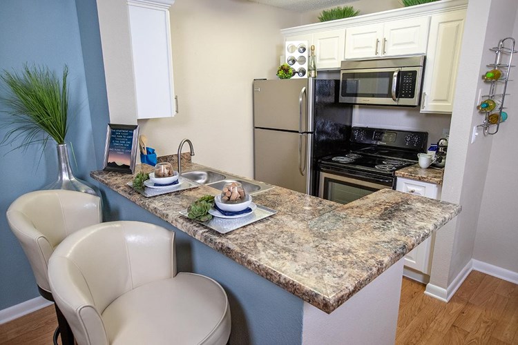 Newly updated kitchens with white cabinetry, granite counter tops, and stainless steel appliances.