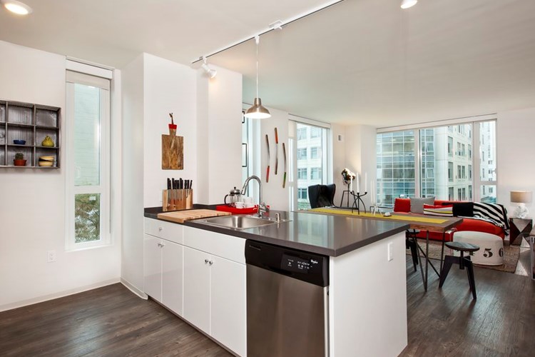 Kitchen with white cabinetry, stainless steel appliances, chrome countertops and hard surface flooring