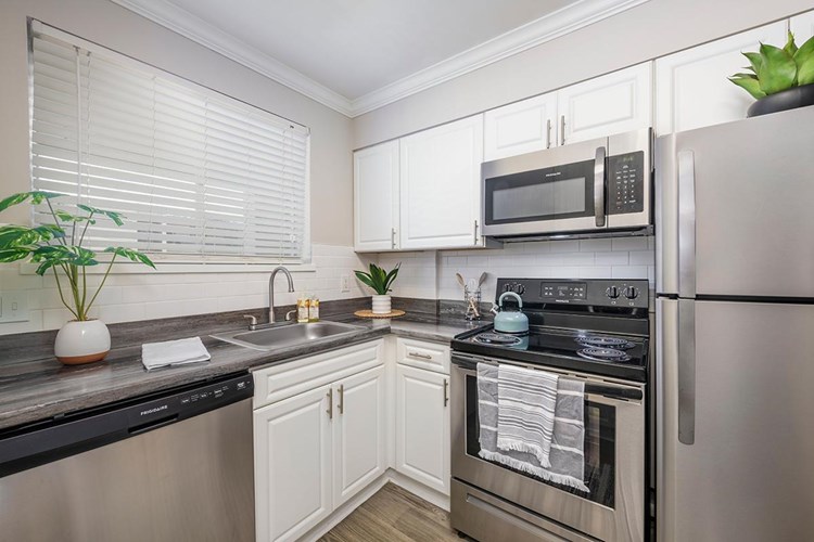 Newly remodeled kitchens with white cabinetry, and stainless steel appliances.