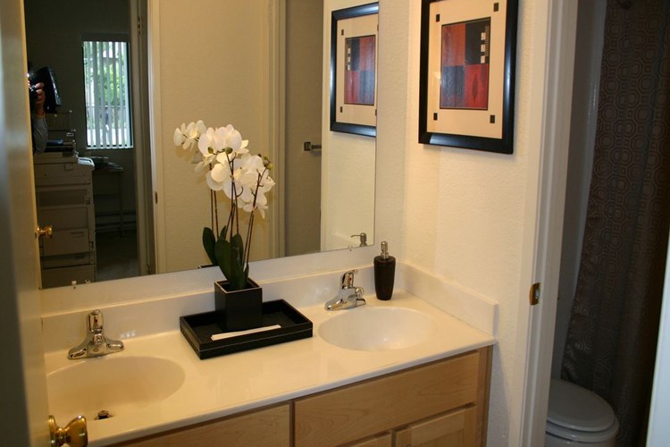 Bathroom with double vanity, oak cabinetry and white countertop