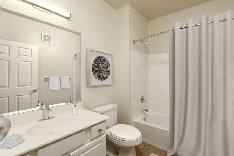 Renovated Package I bath with white countertops, white cabinetry, and hard surface flooring
