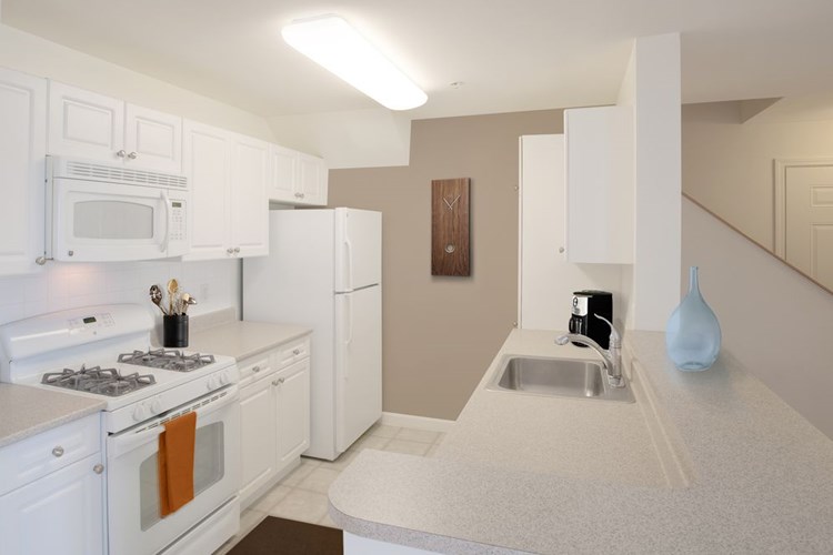 Phase I Classic Package I apartment kitchen with white cabinetry and white appliances 