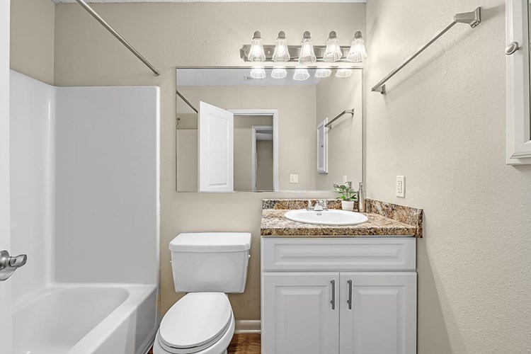 Bathrooms feature large mirrors, granite-style countertops and a medicine cabinet.