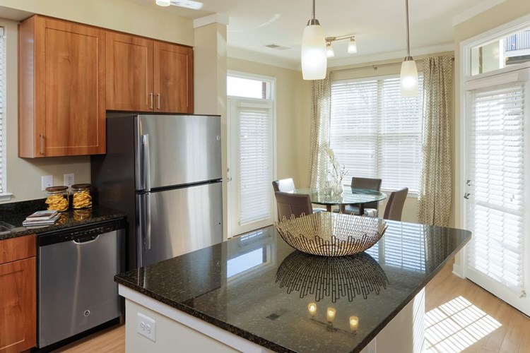 Open concept kitchen with granite countertops, stainless-steel appliances, kitchen island and hard surface flooring