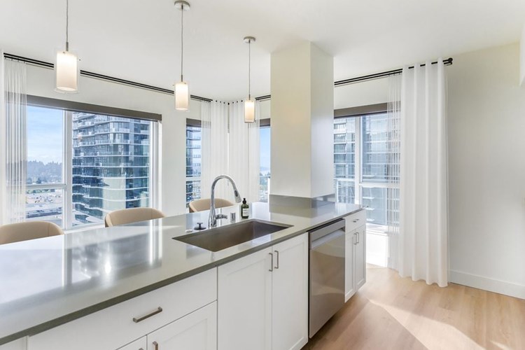 Renovated Package I kitchen with white cabinetry, grey quartz countertops, and hard surface flooring