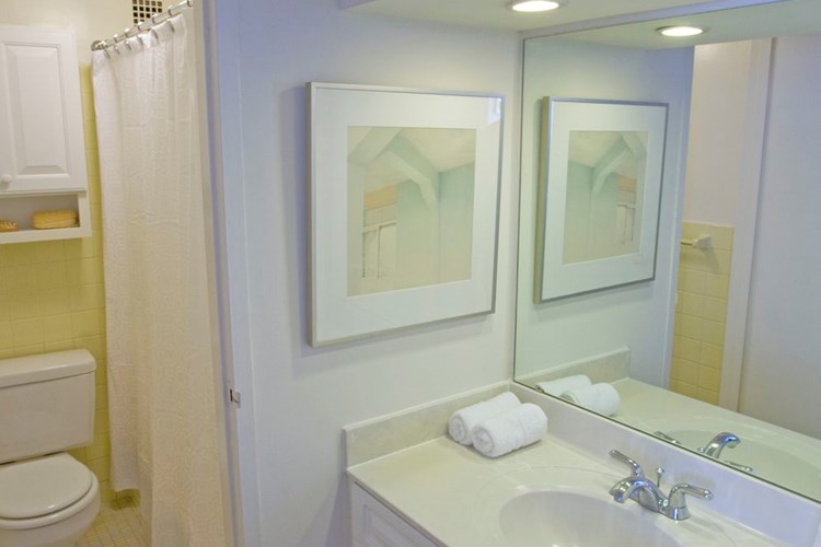 Studio apartment bathrooms feature vanities with plenty of storage space, a seamless, integrated bowl and large mirror