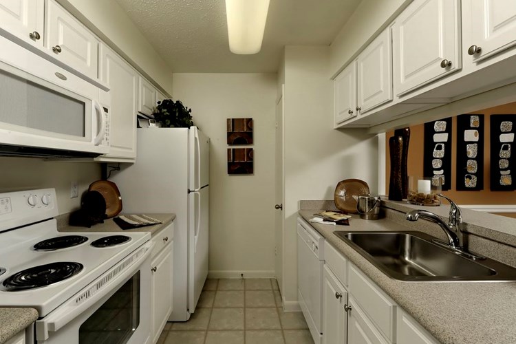 Finish Package I kitchen with white cabinetry, beige laminate countertops, white appliances and tile flooring