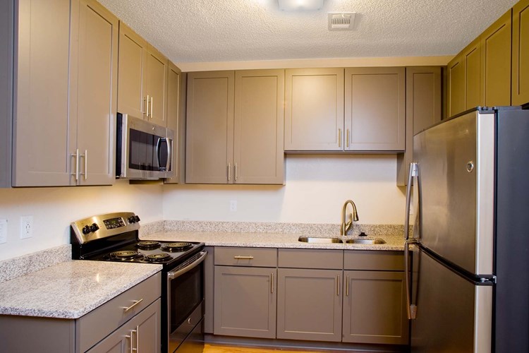 Granite countertops, designer cabinets and new stainless steel appliances in renovated kitchens