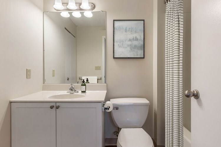 Classic Package I bath with white laminate countertops, white cabinetry, and hard surface flooring