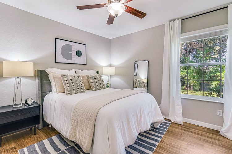 Over-sized master bedrooms featuring a ceiling fan, wood-style flooring and large windows.
