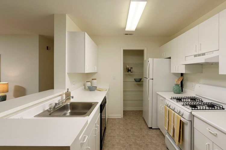 Classic Package I kitchen with white cabinetry, white laminate countertops, white appliances, and vinyl tile flooring