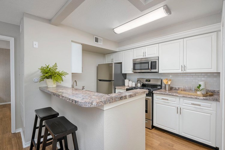 Kitchens featuring stainless steel appliances, granite-style countertops, and a subway tile backsplash.