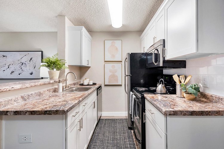 Galley-style kitchens featuring granite-style countertops, wood-style flooring, and stainless steel appliances.