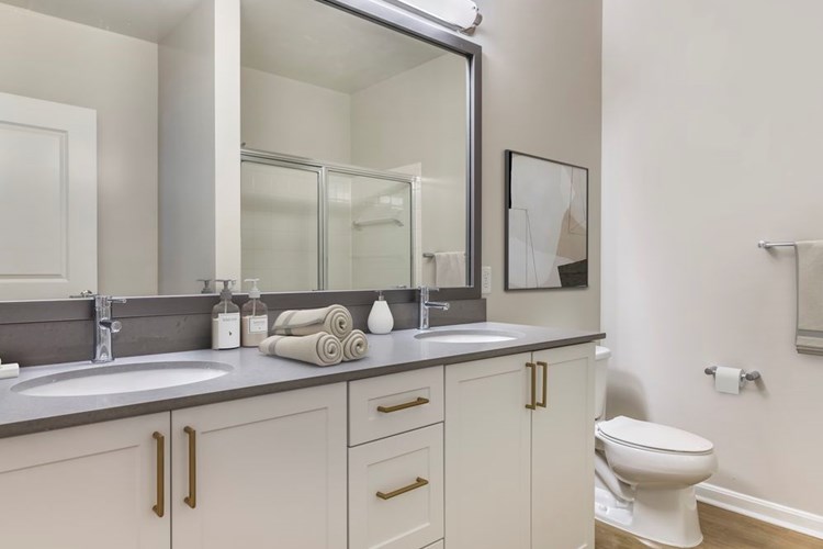 Renovated Package II bath with grey quartz countertops, white cabinetry, and hard surface flooring