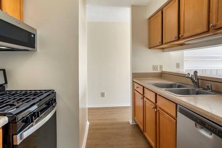 Renovated Package I kitchen with stainless steel appliances, laminate countertops, oak cabinetry, and hard surface flooring