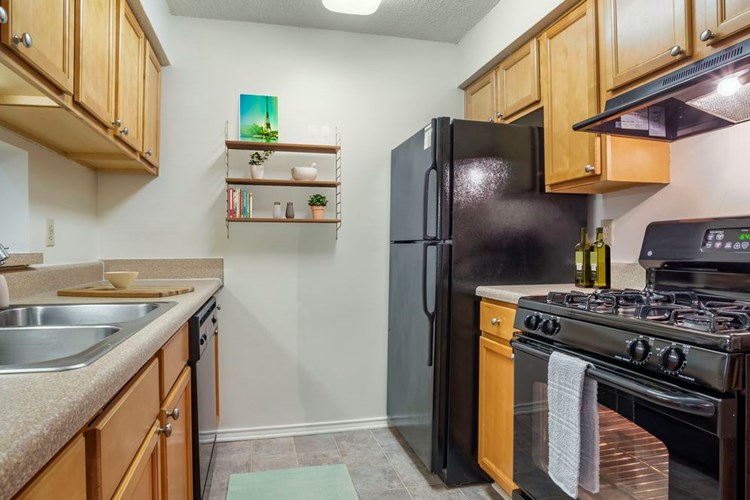 Classic Package kitchen with black appliances, laminate countertops, and tile flooring