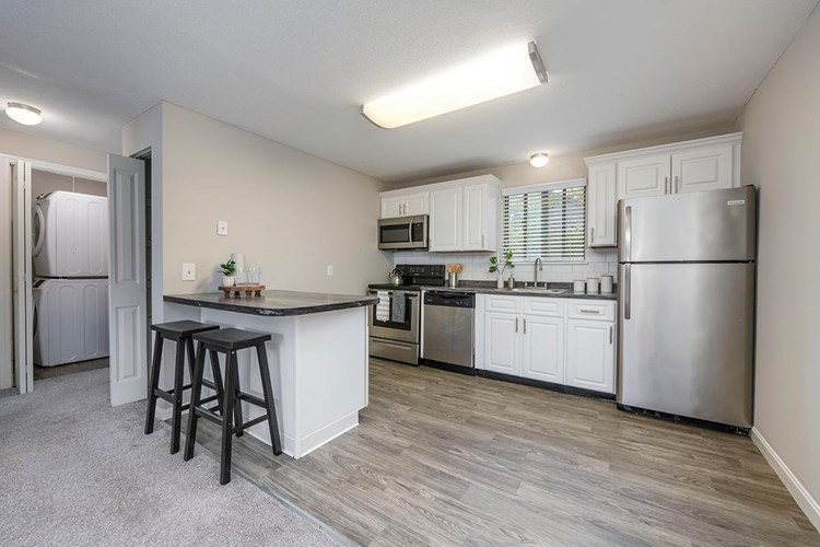 Spacious kitchens featuring wood-style flooring, granite-style countertops, and stainless steel appliances.