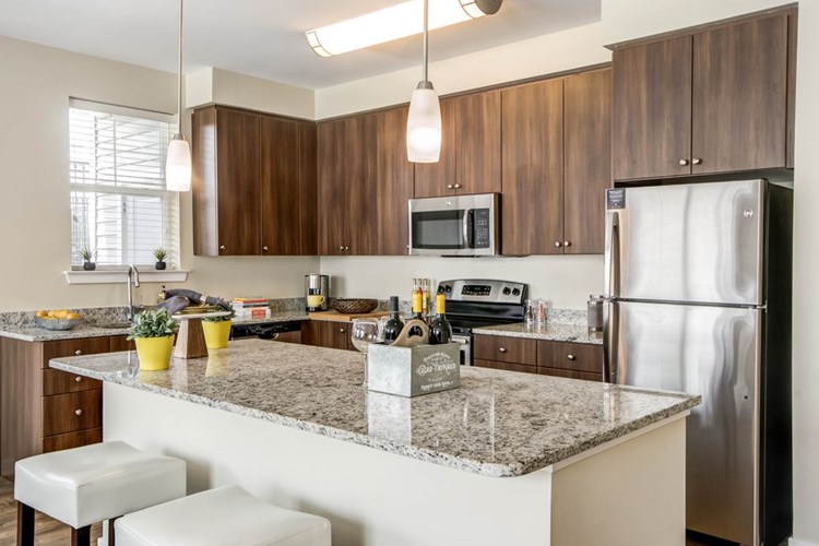 Two bedroom open concept kitchen with granite countertops, stainless-steel appliances, kitchen island and hard surface flooring