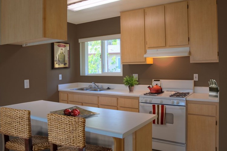 Classic Package I kitchen with oak cabinetry, white laminate countertops, white appliances, and hard surface flooring