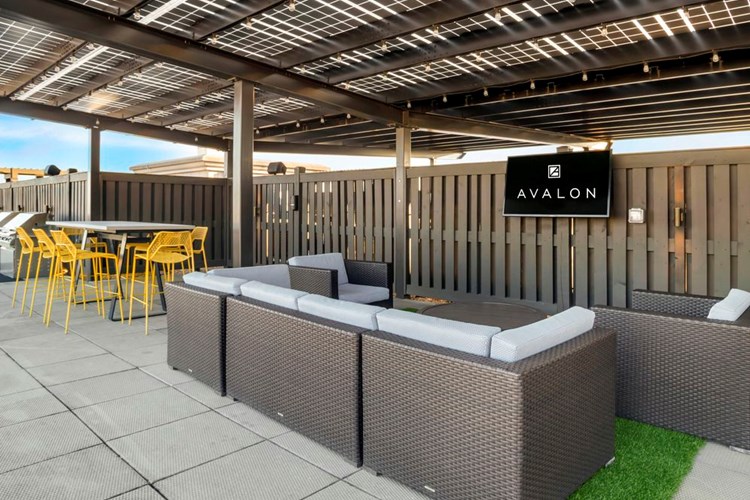 Rooftop terrace with flatscreen TV, lounge seating, and dining area