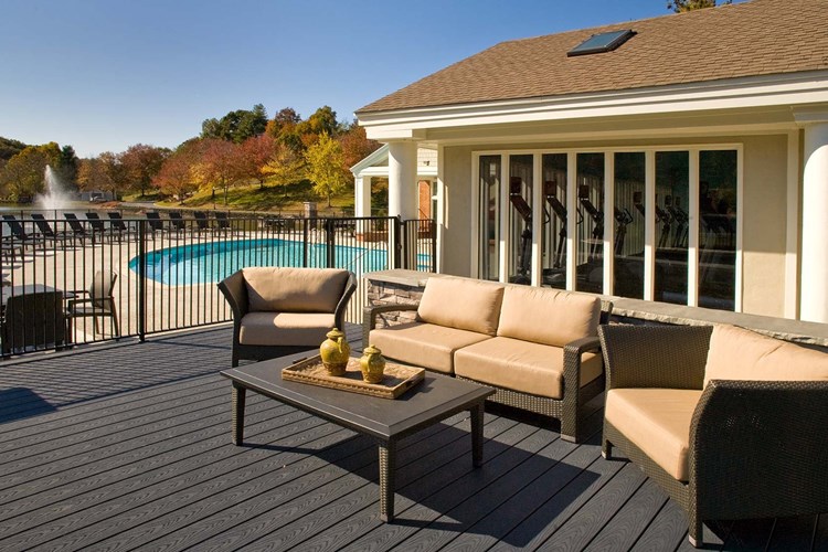 Lounge with friends on the deck with tables and a stainless steel grill