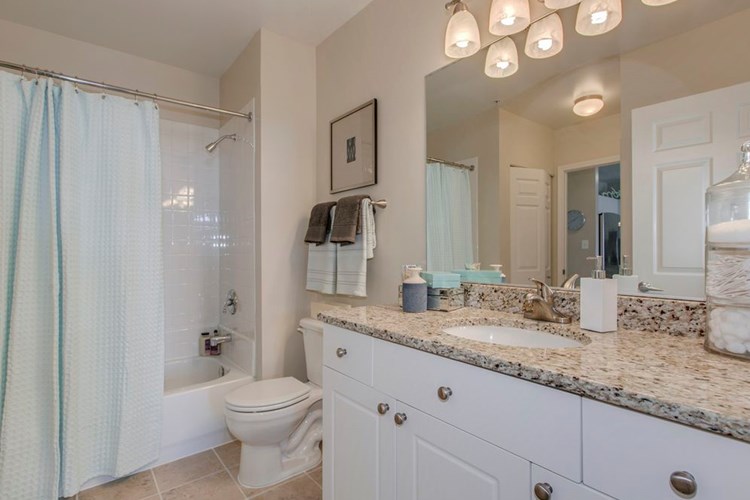 Bathroom with white cabinetry, granite countertop and tile flooring