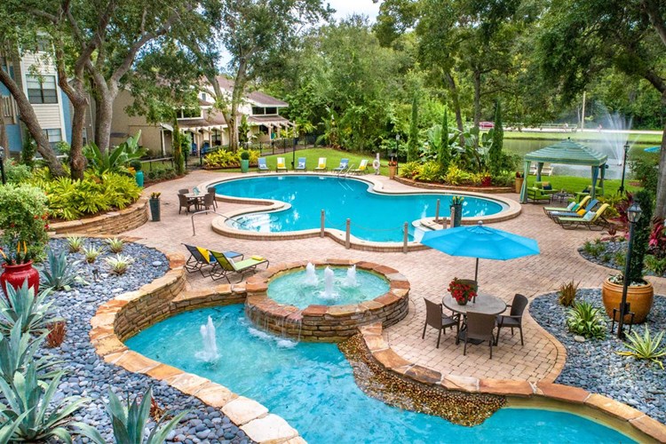 Beautiful, lush landscaping and fountains surrounds the pool area.