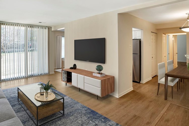 Renovated Package I living room and dining area featuring hard surface flooring in select units