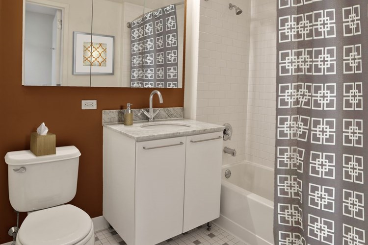 Classic Package I bath with white marbled granite countertops, white cabinetry, and hard surface flooring