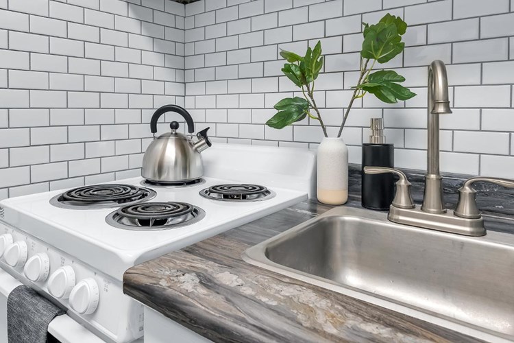 Premium white subway tile backsplash in all kitchens add to the modern look of our premier studios.