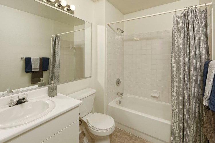 Classic Package I bath with white cabinetry, white laminate countertop, and vinyl tile flooring